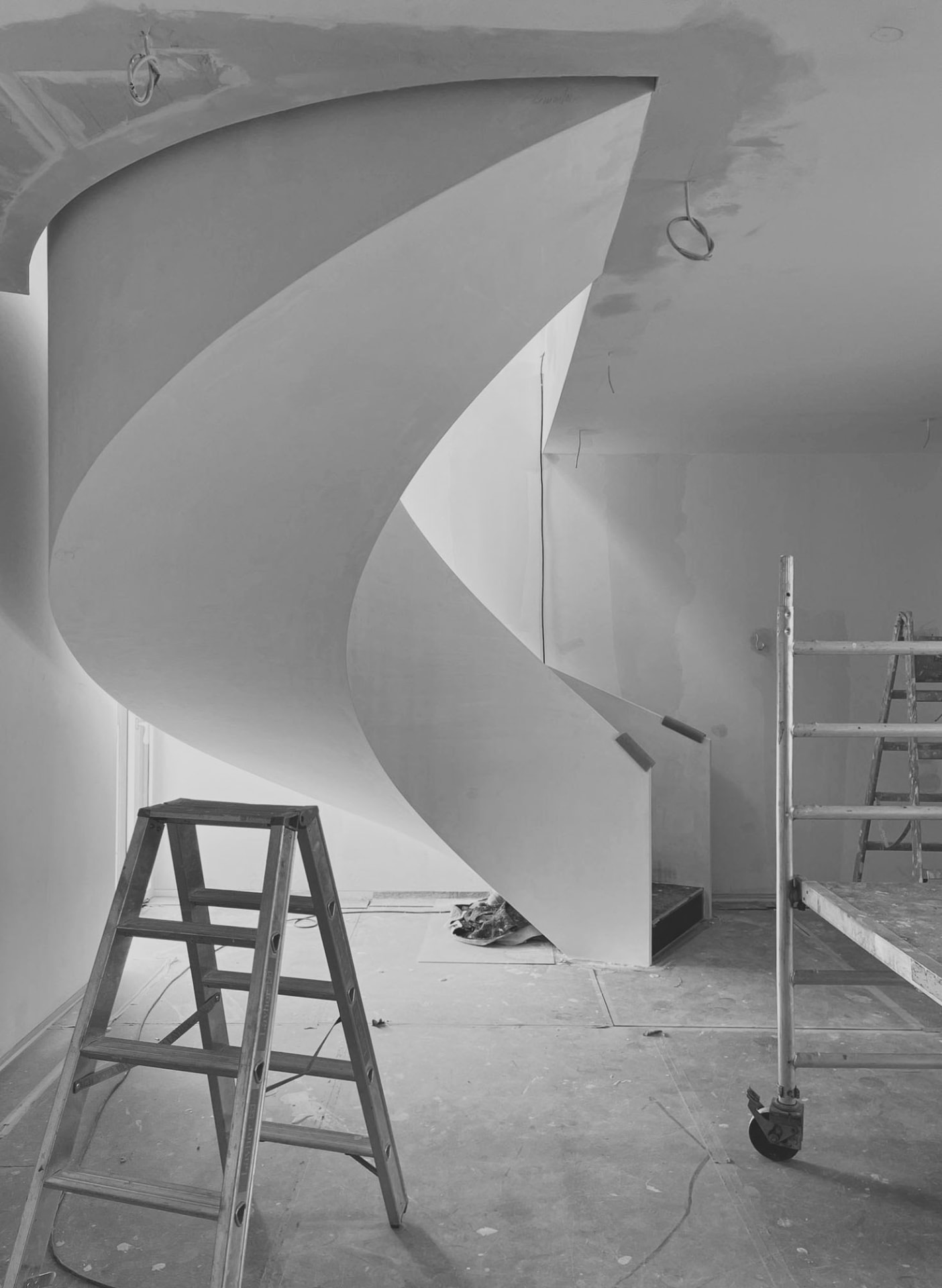 Innenraum mit geschwungener Treppe im Rohbau
